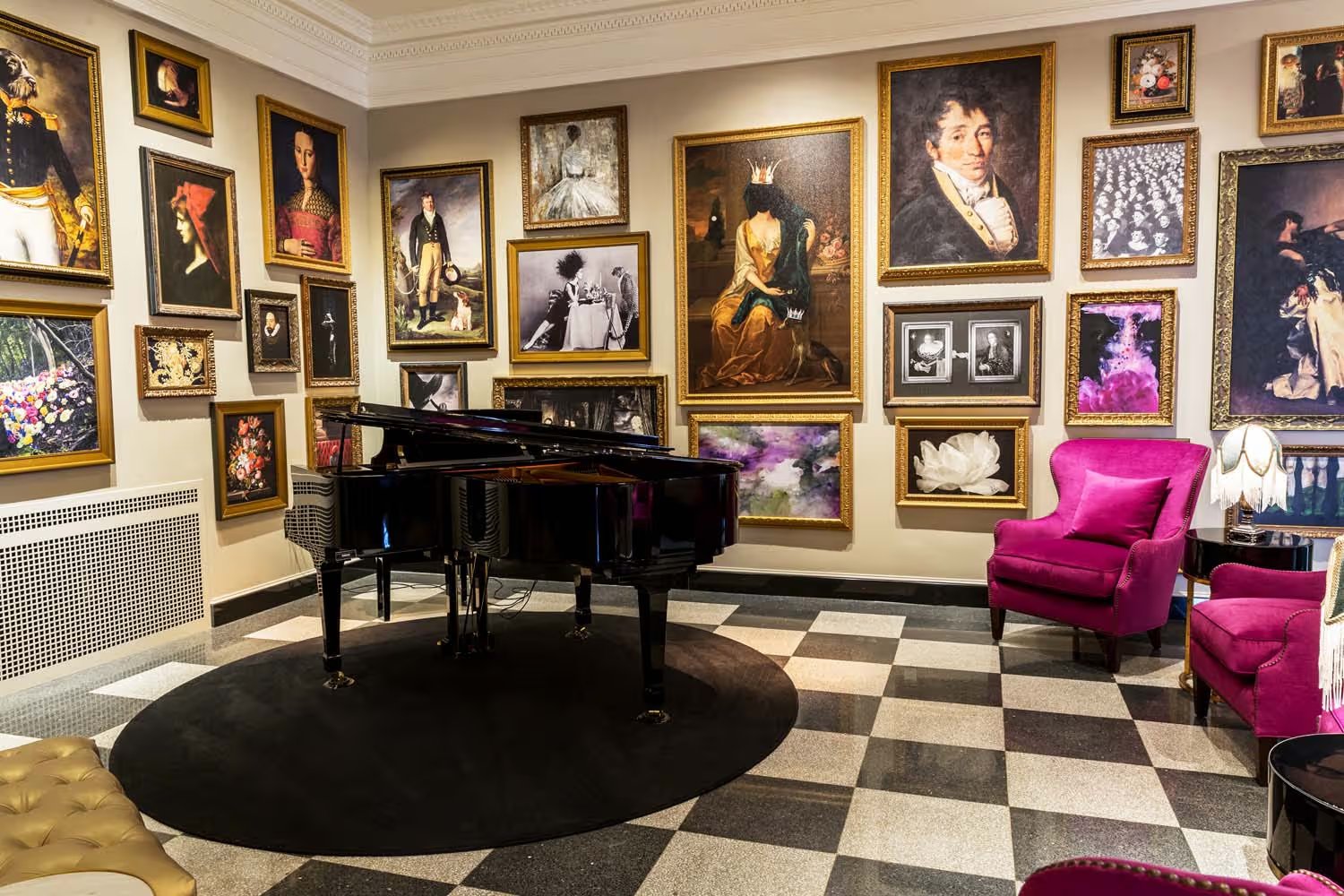 The Raleigh Room at the Historic Cavalier Hotel: a gallery wall of gilt-framed portraits, a grand piano, and magenta velvet armchairs